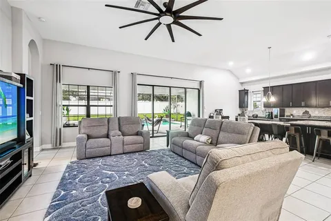 a living room with furniture kitchen view and a large window