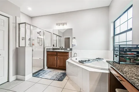 a bathroom with a granite countertop sink and a bathtub