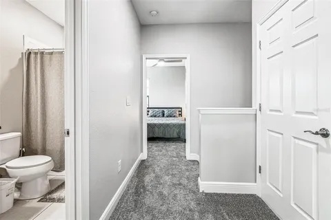 a bed sitting in a bedroom next to a window and dresser