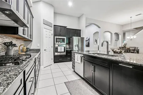 a kitchen with stainless steel appliances granite countertop a sink and a stove