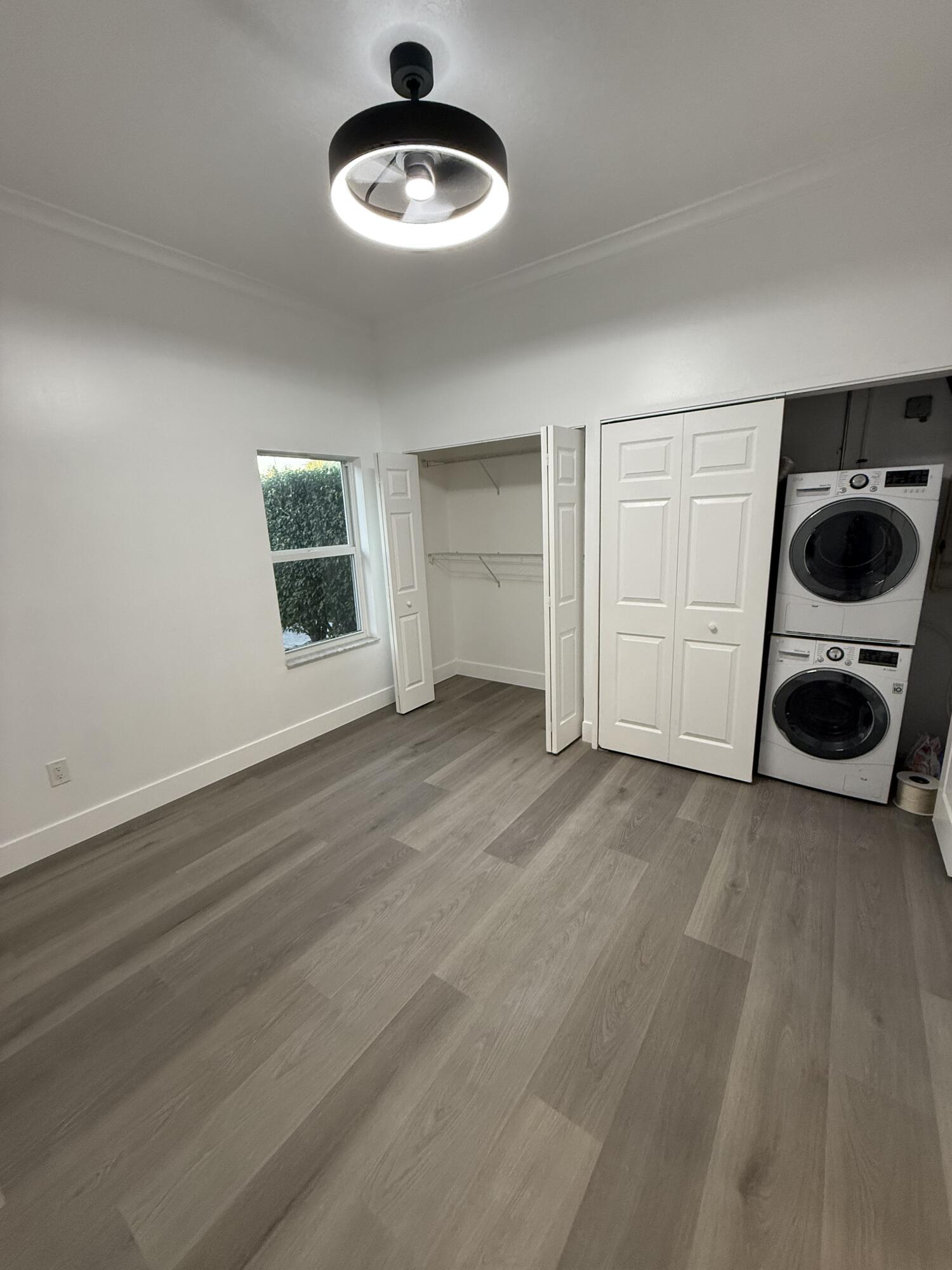 11865 Ellison Wilson Road, Unit A North Palm Beach, FL 33408 - Photo 8 of 12 an empty room with a chandelier fan and windows