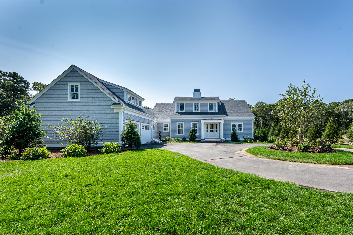 8 Bascom Hollow Harwich, MA 02645 - Photo 3 of 13 a front view of a house with a yard and garage