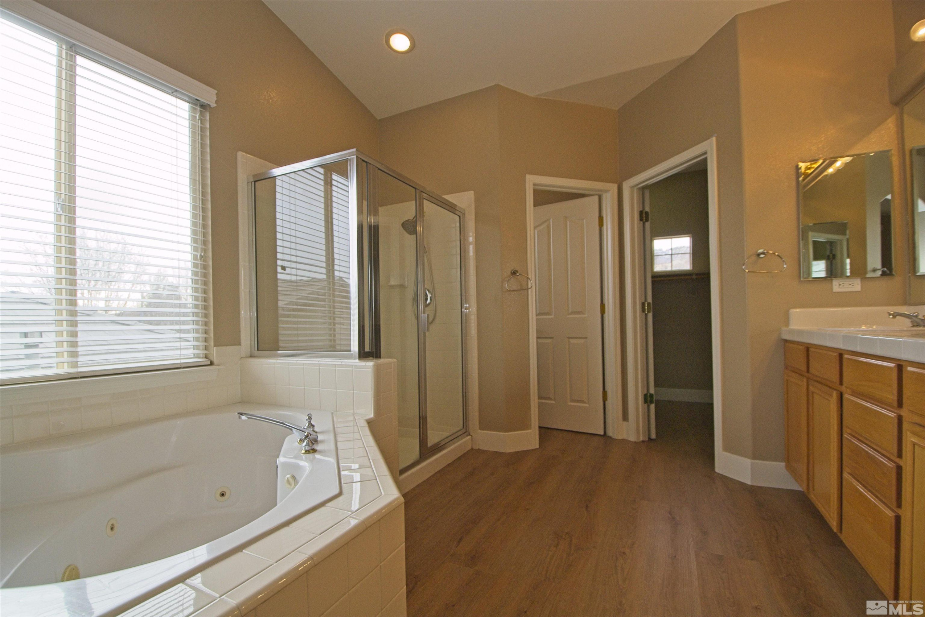 74 River Front Drive Reno, NV 89523 - Photo 12 of 28 a bathroom with a tub a sink and a large mirror