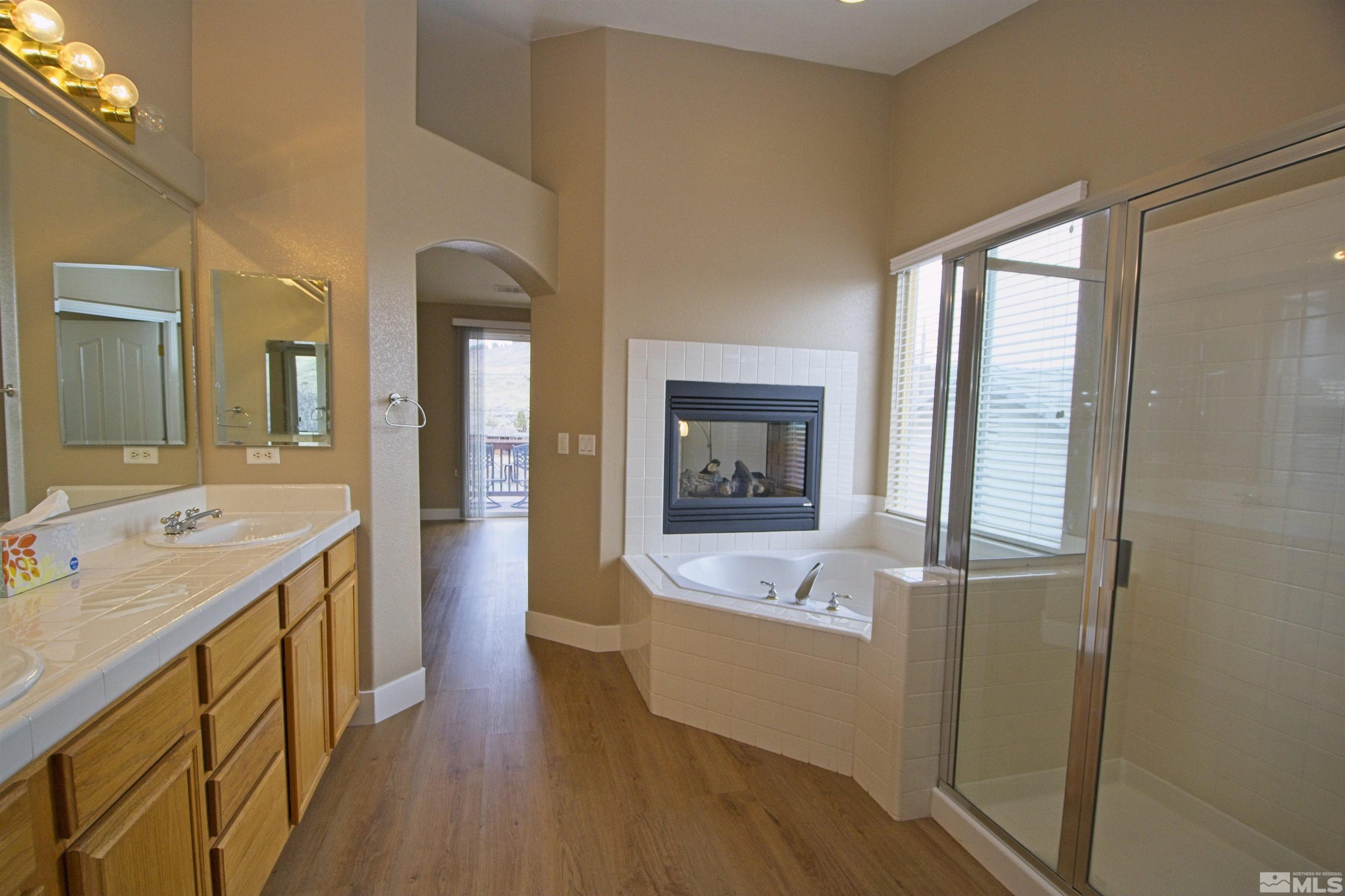 74 River Front Drive Reno, NV 89523 - Photo 15 of 28 a en suite bathroom with a granite countertop sink a mirror and a bathtub