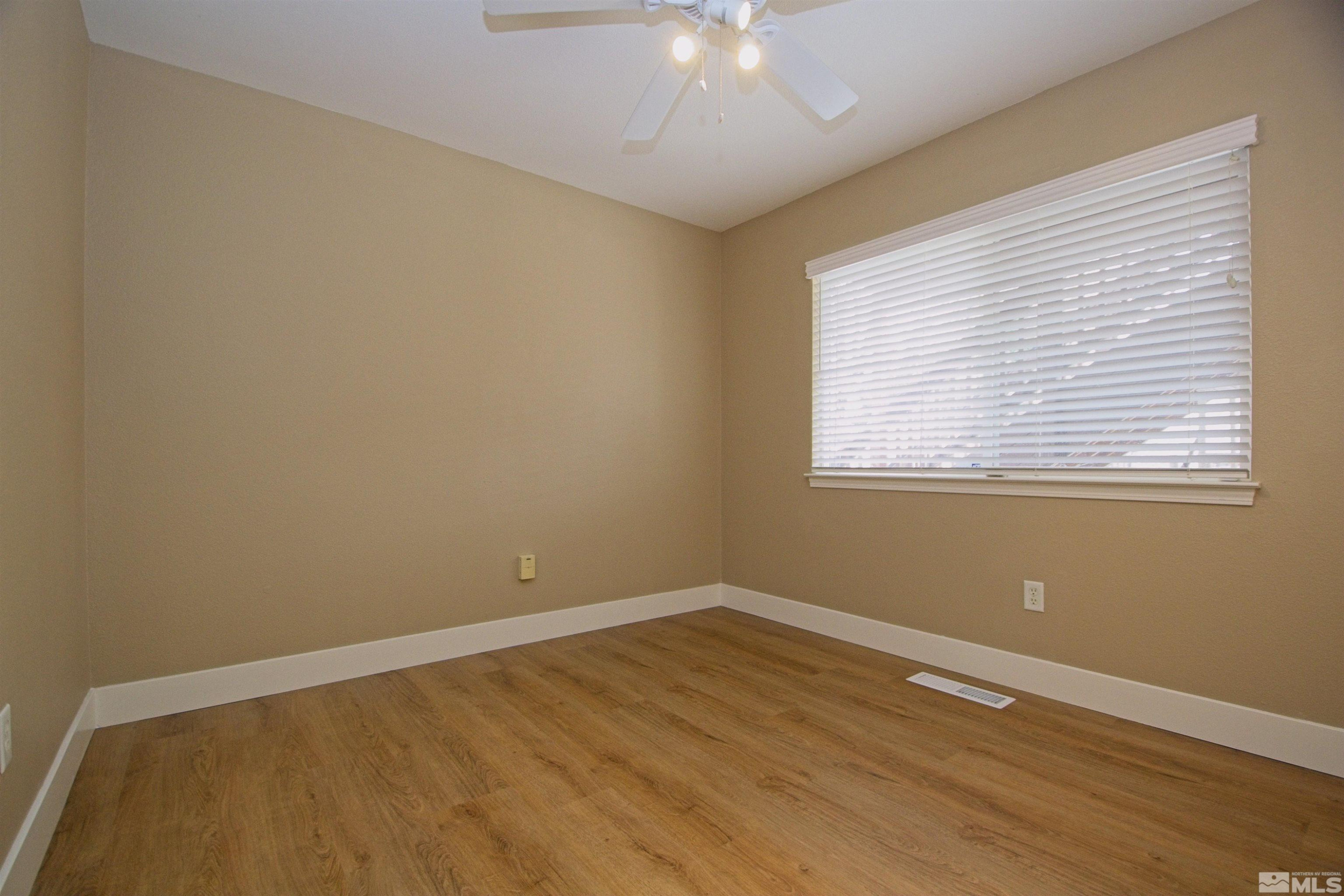 74 River Front Drive Reno, NV 89523 - Photo 19 of 28 a view of an empty room with wooden floor and a window