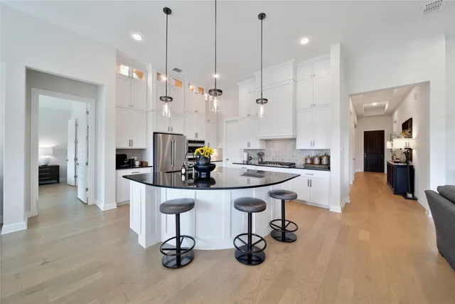 a kitchen with stainless steel appliances kitchen island granite countertop a sink and a refrigerator