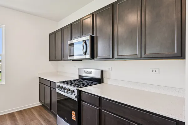 a kitchen with stainless steel appliances a stove microwave and cabinets