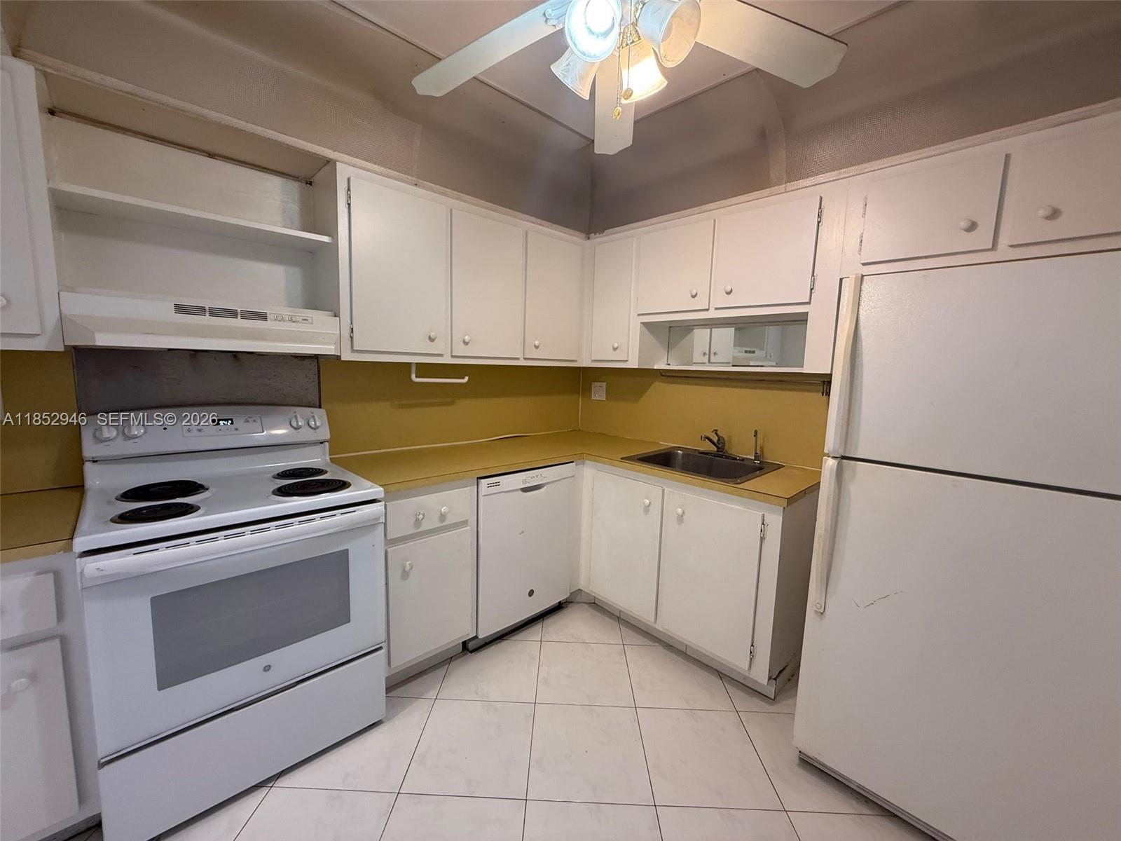 500 Three Islands Boulevard, Unit 715 Hallandale Beach, FL 33009 - Photo 12 of 16 a kitchen with cabinets stainless steel appliances and a counter space