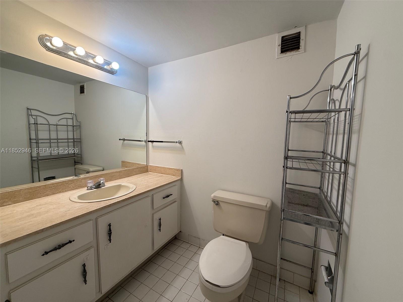 500 Three Islands Boulevard, Unit 715 Hallandale Beach, FL 33009 - Photo 13 of 16 a bathroom with a toilet sink and mirror
