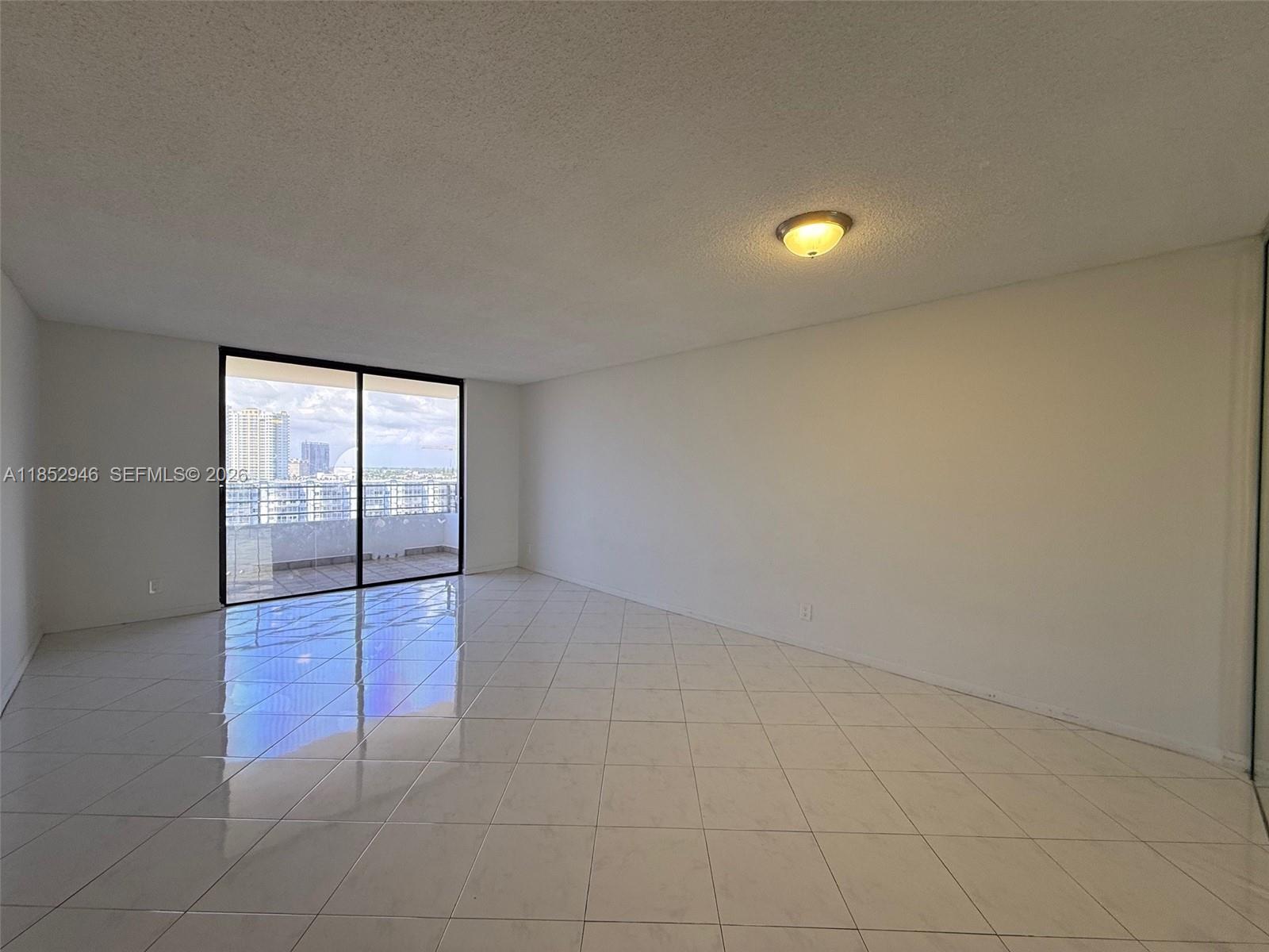 500 Three Islands Boulevard, Unit 715 Hallandale Beach, FL 33009 - Photo 6 of 16 an empty room with sliding glass door