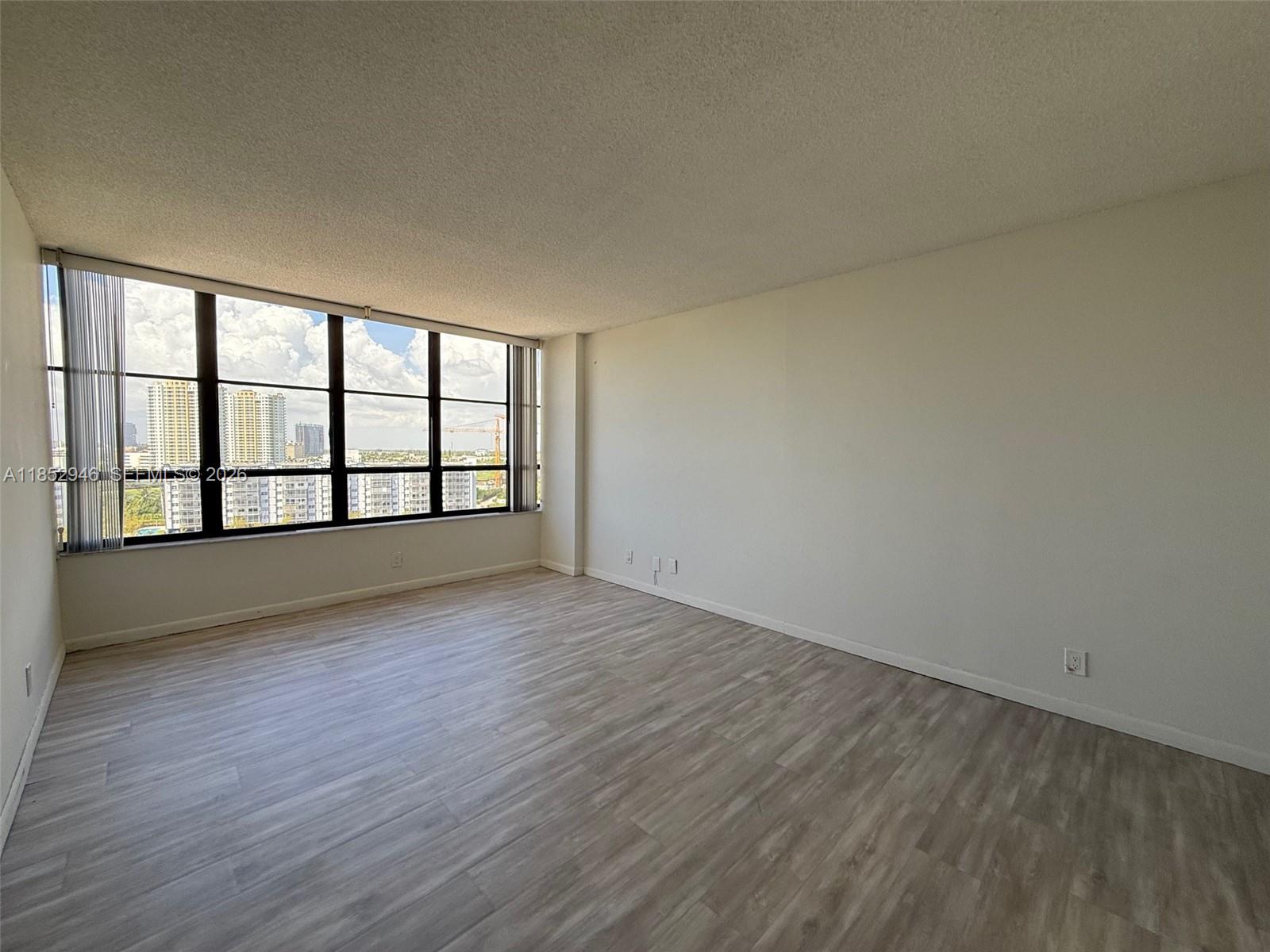 500 Three Islands Boulevard, Unit 715 Hallandale Beach, FL 33009 - Photo 10 of 16 wooden floor in an empty room with a window