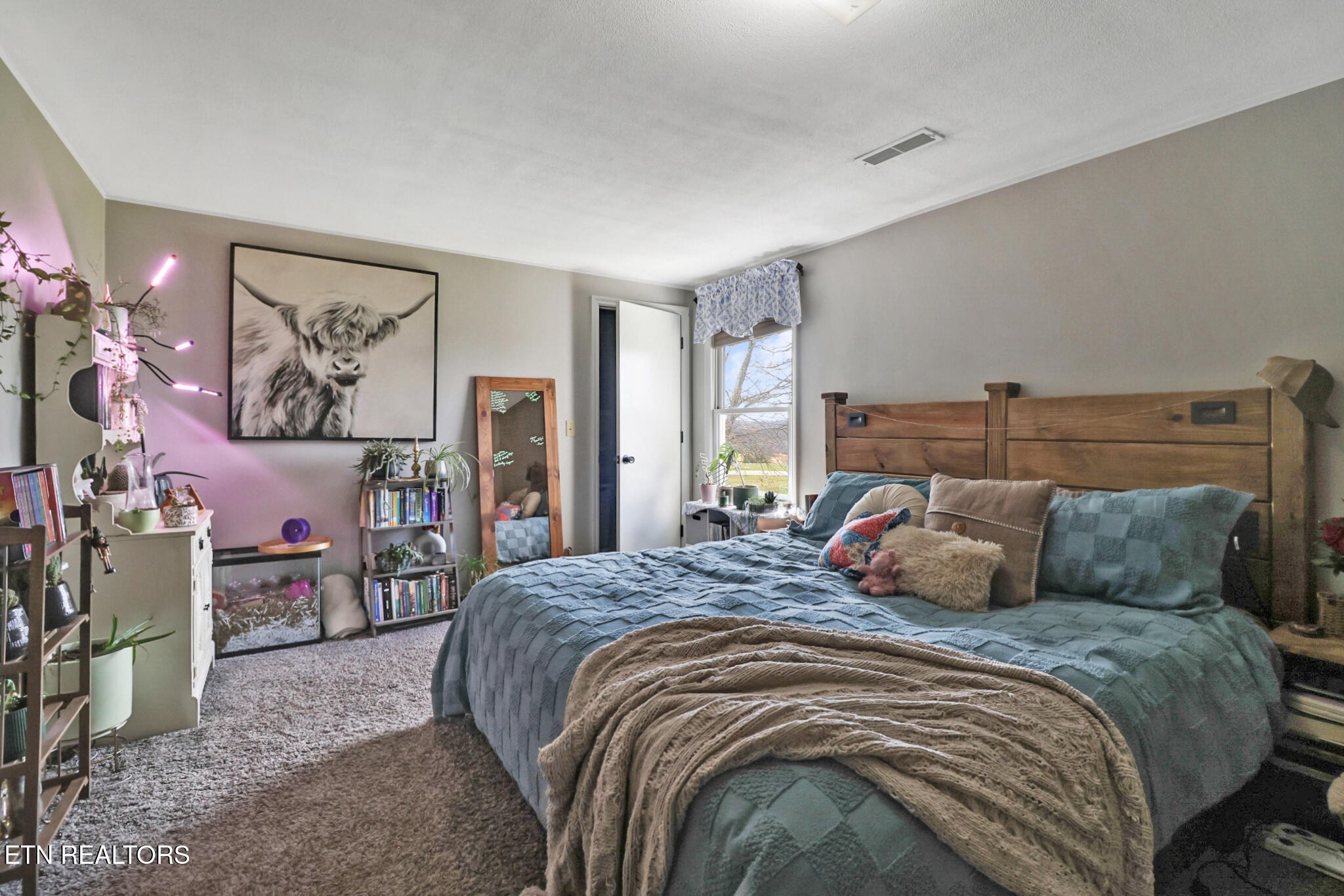 7616 Plateau Road Crossville, TN 38571 - Photo 23 of 60 a bedroom with a large bed and a chandelier