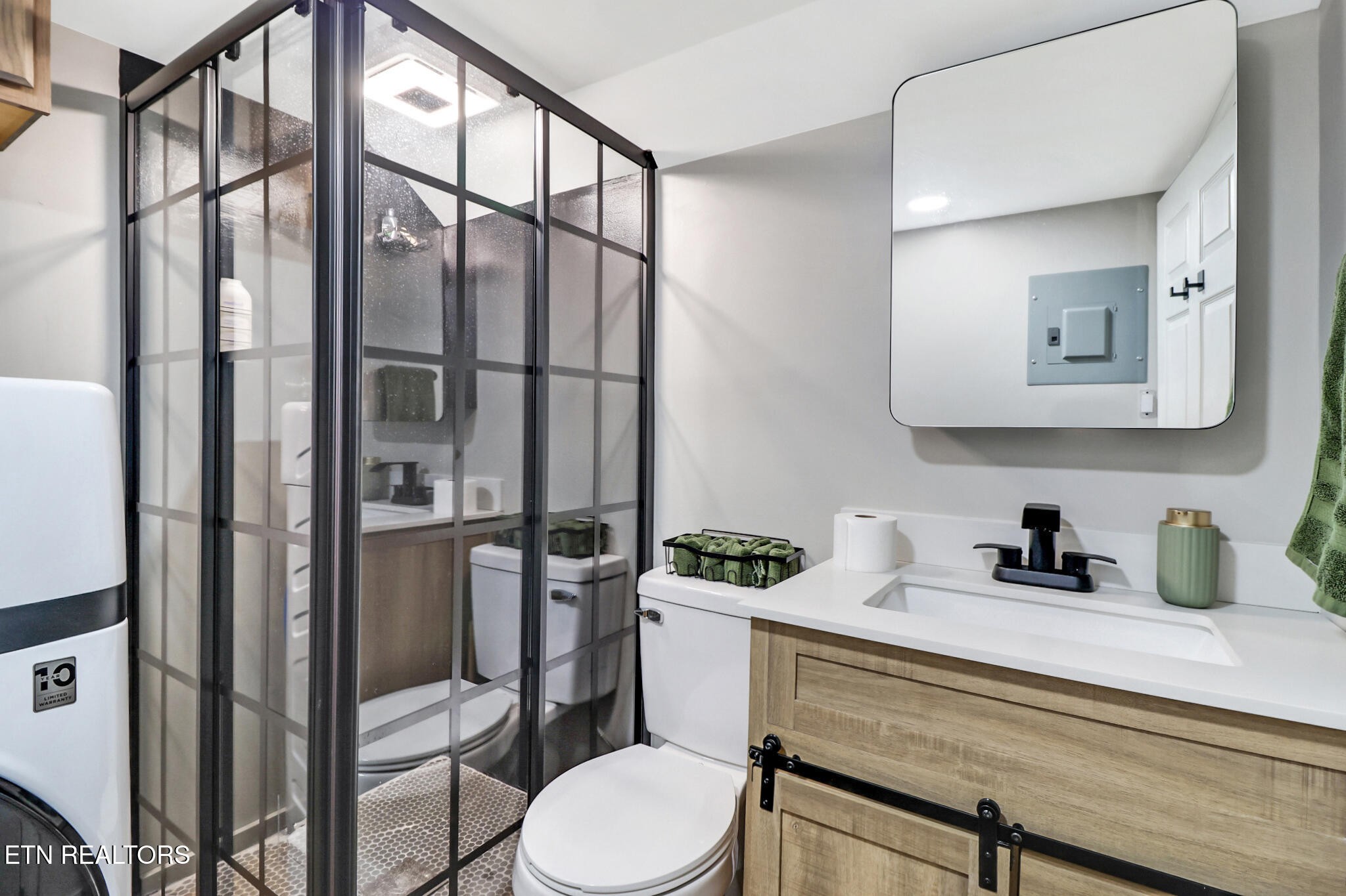 7616 Plateau Road Crossville, TN 38571 - Photo 44 of 60 a bathroom with a toilet a sink and glass door
