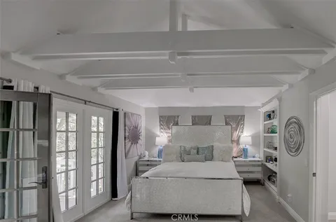 a bedroom with a large bed and a chandelier