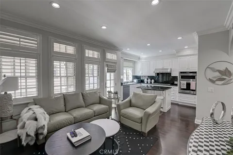 a living room with furniture kitchen view and large windows