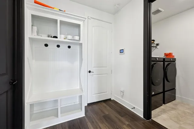 a view of a hallway with wooden floor and closet