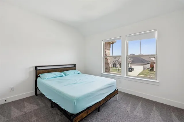 a bed sitting in a bedroom next to a window