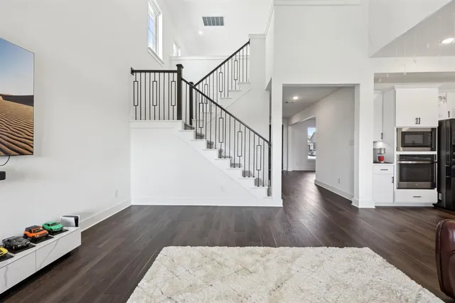 a view of a hallway with wooden floor and stairs