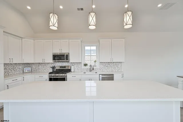 a living room with furniture and a large window with kitchen view