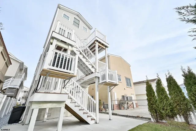 a view of a hallway with wooden floor and a bathroom