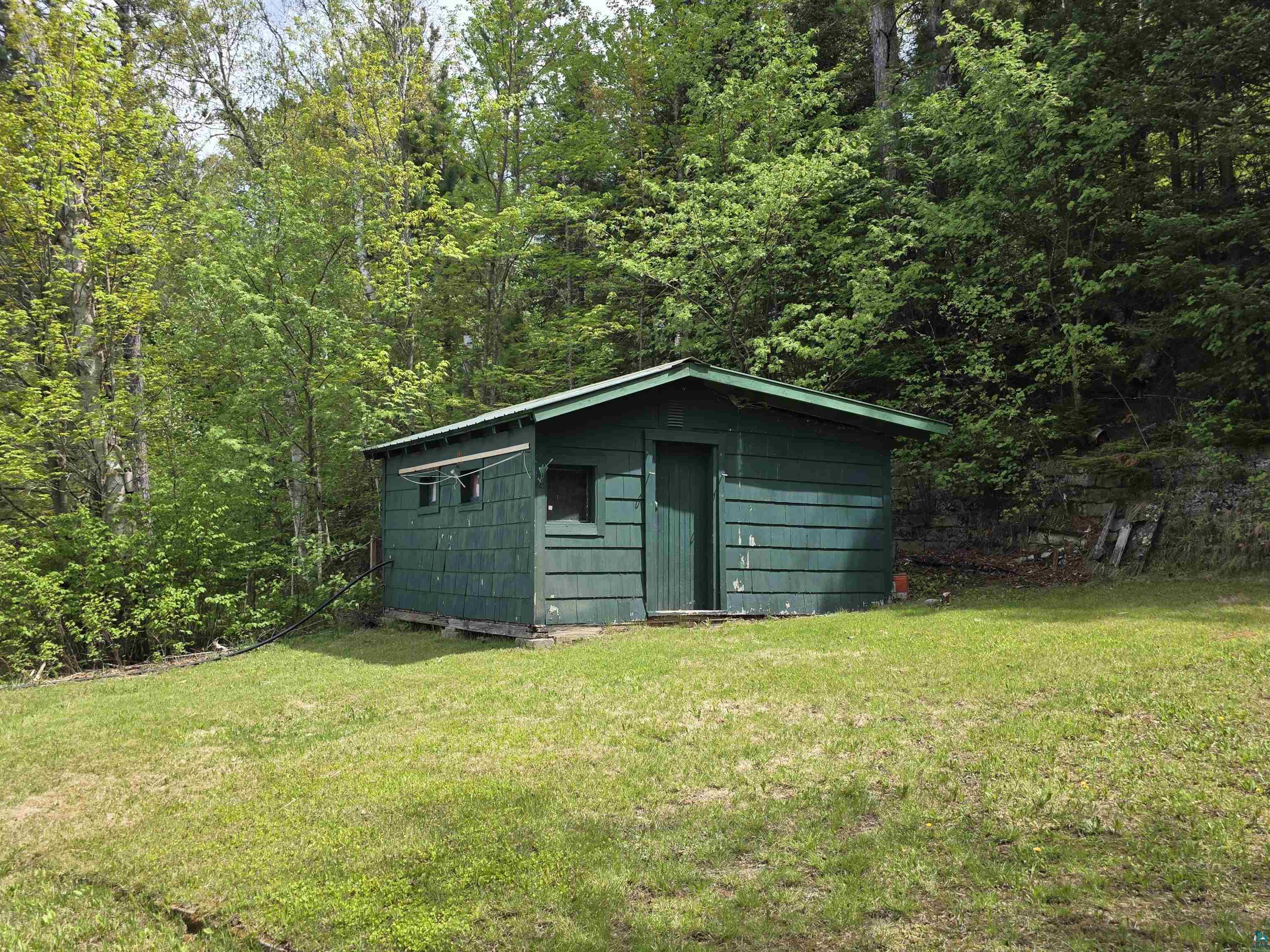 3975 Long Lake Shores Road Eveleth, MN 55734 - Photo 81 of 84 Green-painted utility shed with horizontal siding, featuring a sloped roof and a single entry door