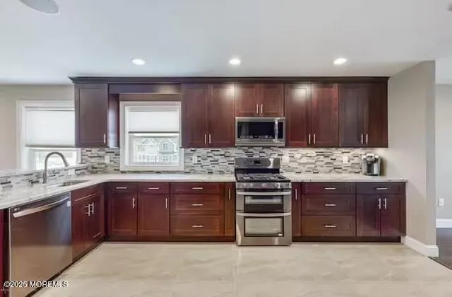 a large kitchen with stainless steel appliances granite countertop a stove and a sink