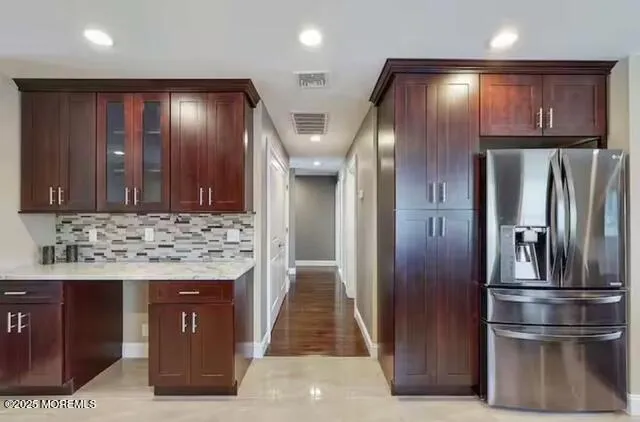 a kitchen with stainless steel appliances granite countertop a refrigerator and a stove