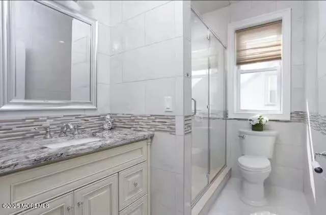 a bathroom with a granite countertop toilet a sink and a mirror