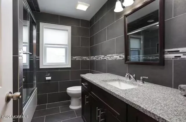 a bathroom with a granite countertop sink a toilet and a mirror