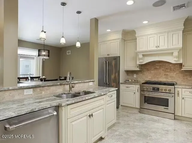 a kitchen with stainless steel appliances granite countertop a sink a stove and a refrigerator