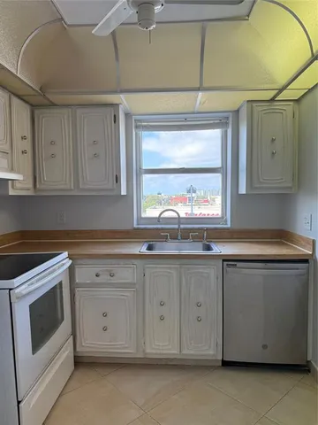 a kitchen with granite countertop white cabinets stainless steel appliances and a sink
