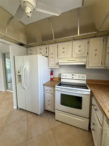a kitchen with white cabinets and white appliances