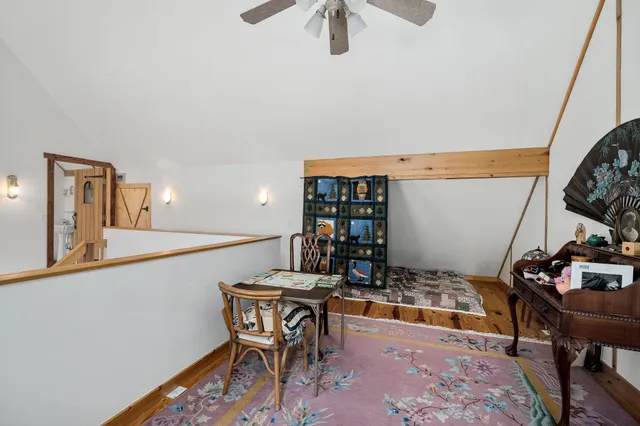 a bedroom with a large bed a flat tv screen and dresser