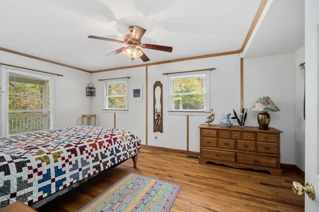 a bedroom with bed and wooden floor