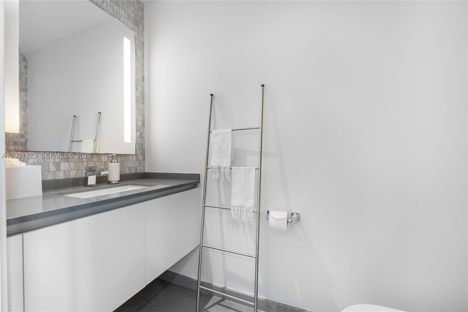 88 Southwest 7th Street, Unit 3208 Miami, FL 33130 - Photo 15 of 16 a bathroom with a sink and mirror