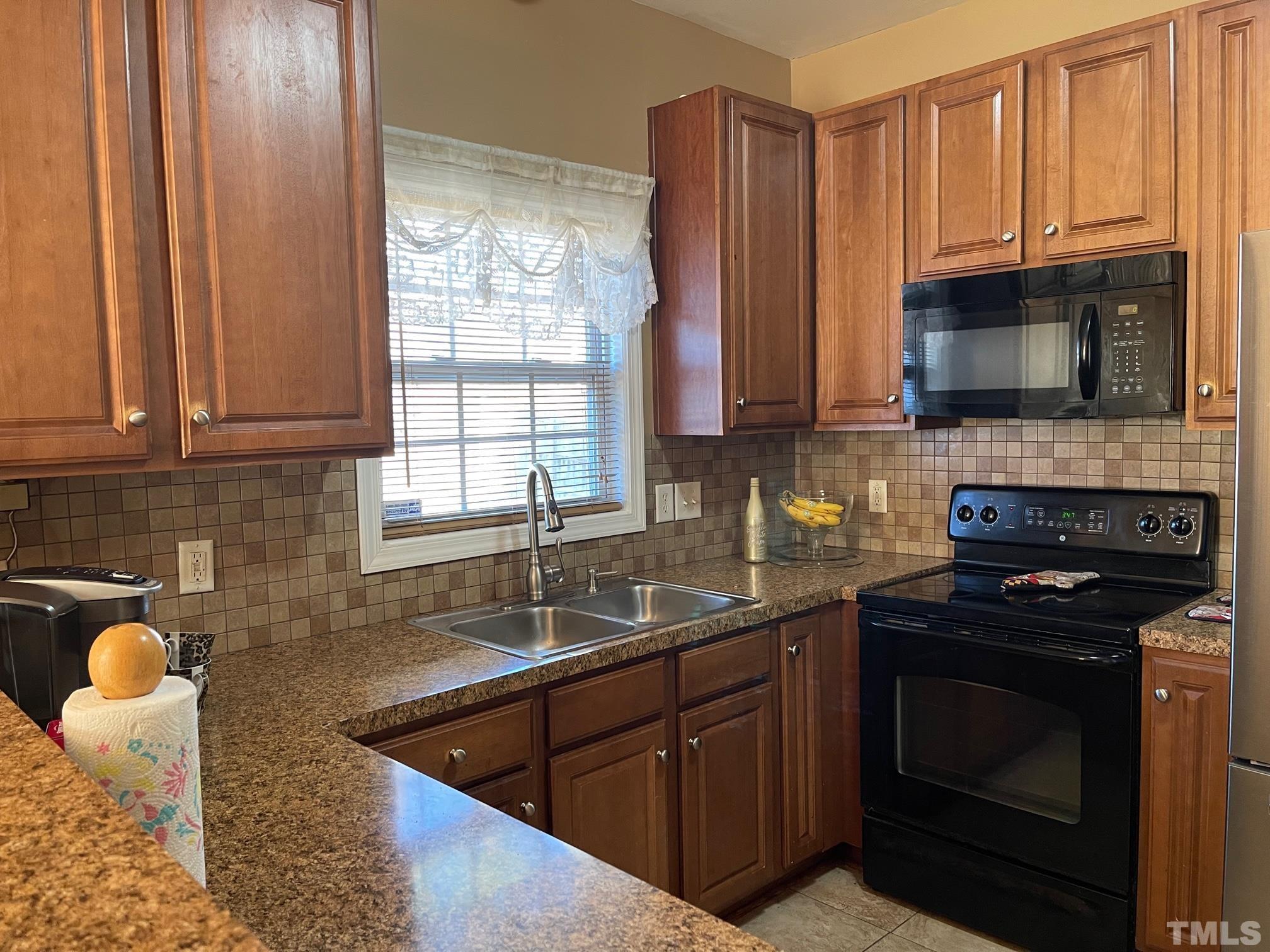 3516 Rendition Street Raleigh, NC 27610 - Photo 12 of 24 a kitchen with granite countertop a stove a sink and a microwave