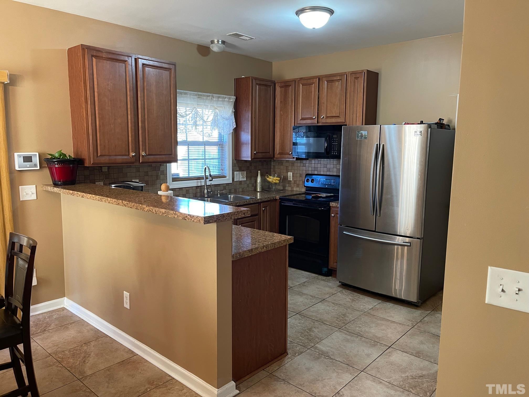 3516 Rendition Street Raleigh, NC 27610 - Photo 9 of 24 a kitchen with stainless steel appliances granite countertop a refrigerator stove microwave and sink