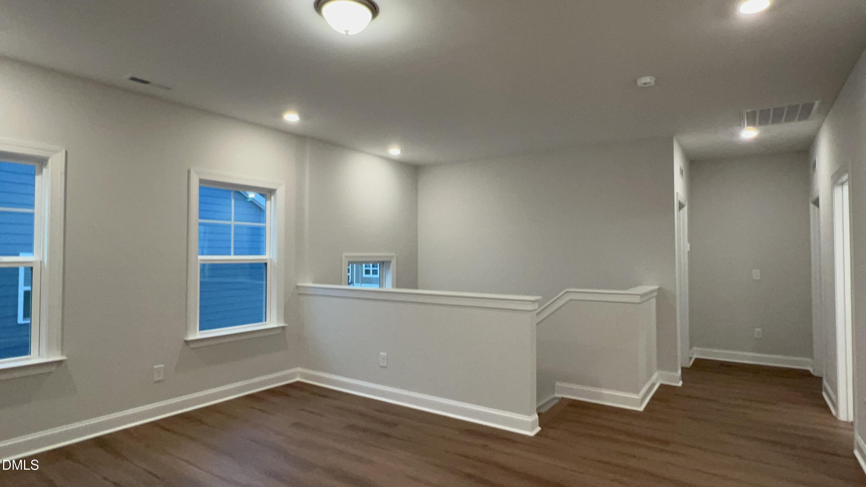 113 Corapeake Way Holly Springs, NC 27539 - Photo 11 of 20 a view of an empty room with wooden floor and a window