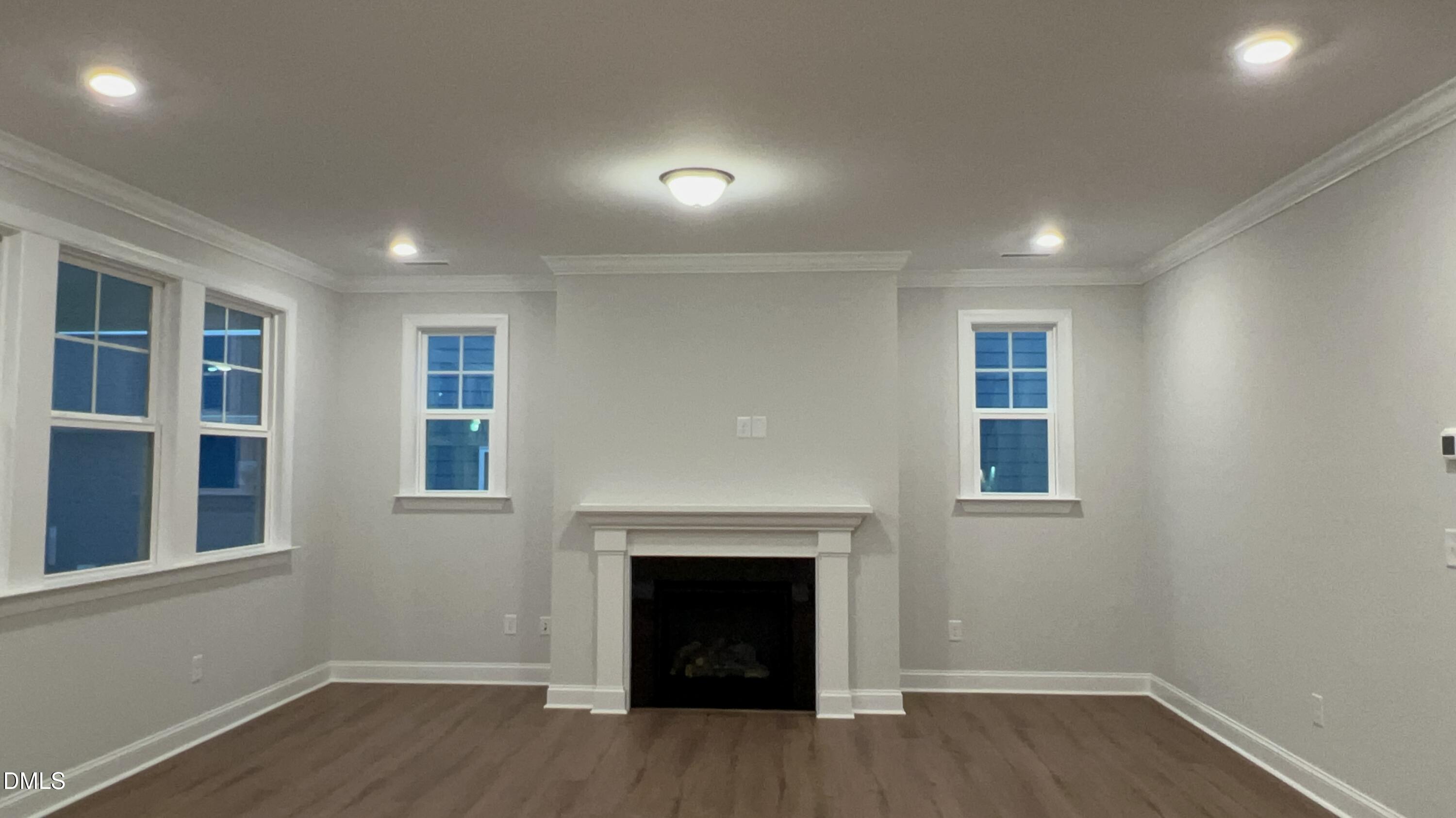 113 Corapeake Way Holly Springs, NC 27539 - Photo 9 of 20 a view of an empty room with wooden floor and a window