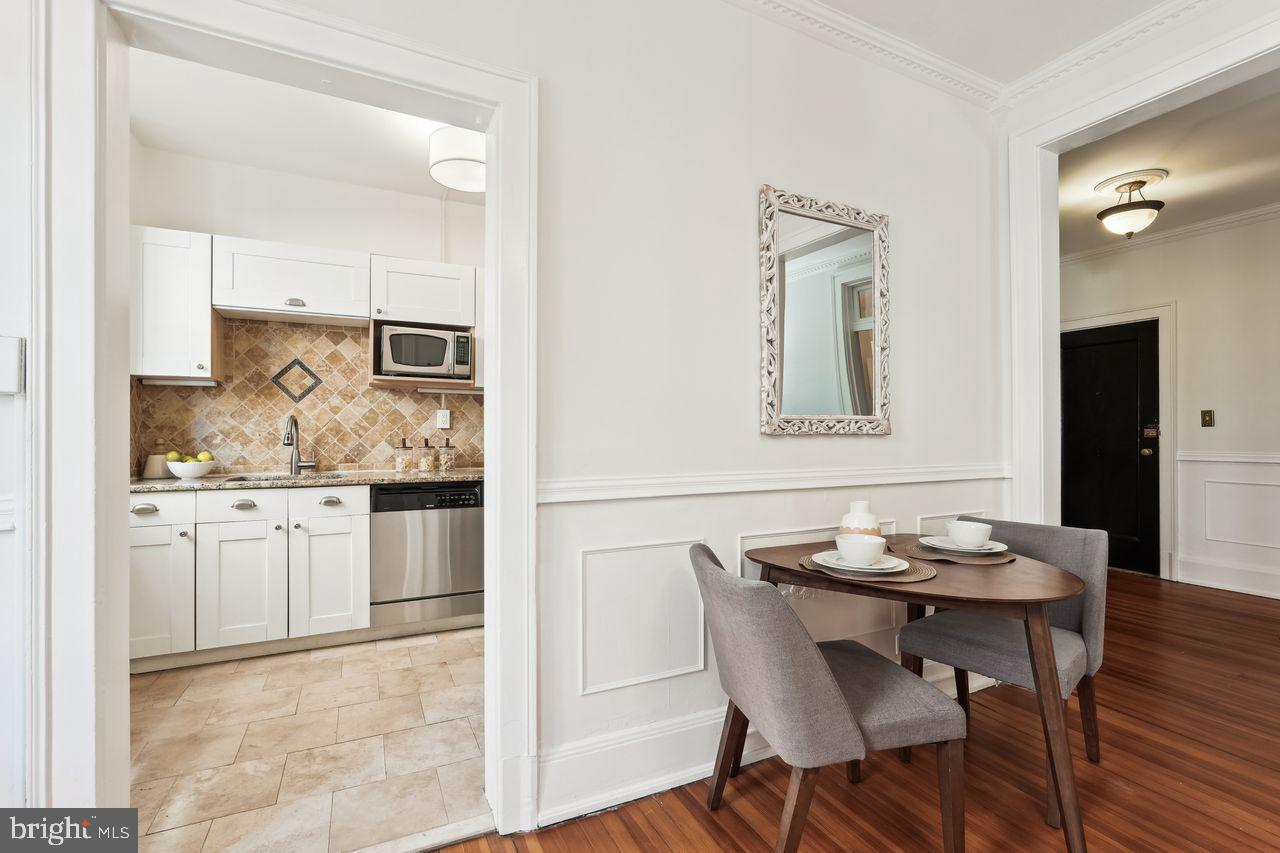 516 A Street Northeast, Unit 205 Washington, DC 20002 - Photo 12 of 24 a kitchen with granite countertop white cabinets and chairs