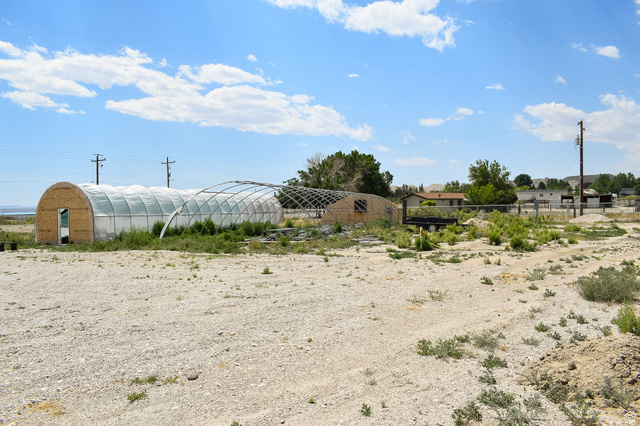 345 North Main Street Clawson, UT 84516 - Photo 12 of 17 Multiple hoop house structures with clear plastic coverings, one featuring a wood-panel end wall