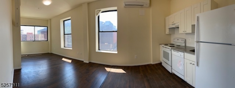 192 Market Street, Unit 7A Newark, NJ 07102 - Photo 7 of 9 an empty room with wooden floor and windows