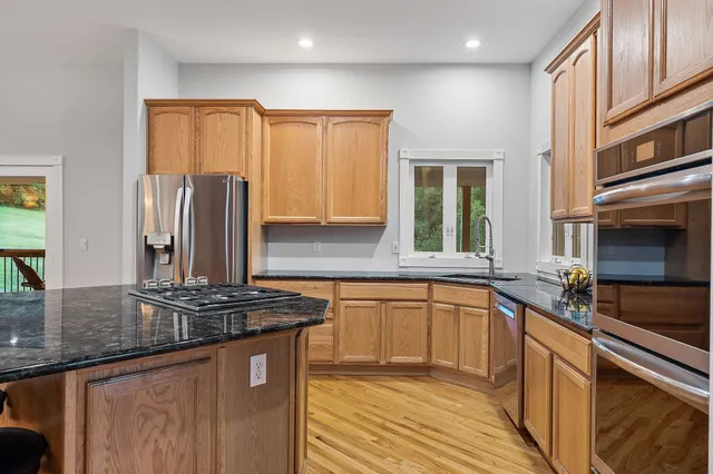 a kitchen with stainless steel appliances granite countertop a sink stove and refrigerator