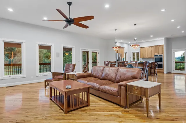 a living room with furniture ceiling fan and a wooden floor