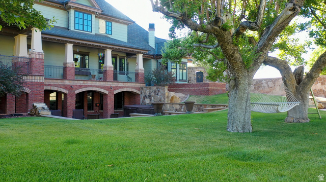 426 West Center Street Parowan, UT 84761 - Photo 84 of 107 Expansive green lawn with mature trees and a multi-level architectural design featuring brick accents and a stucco finish