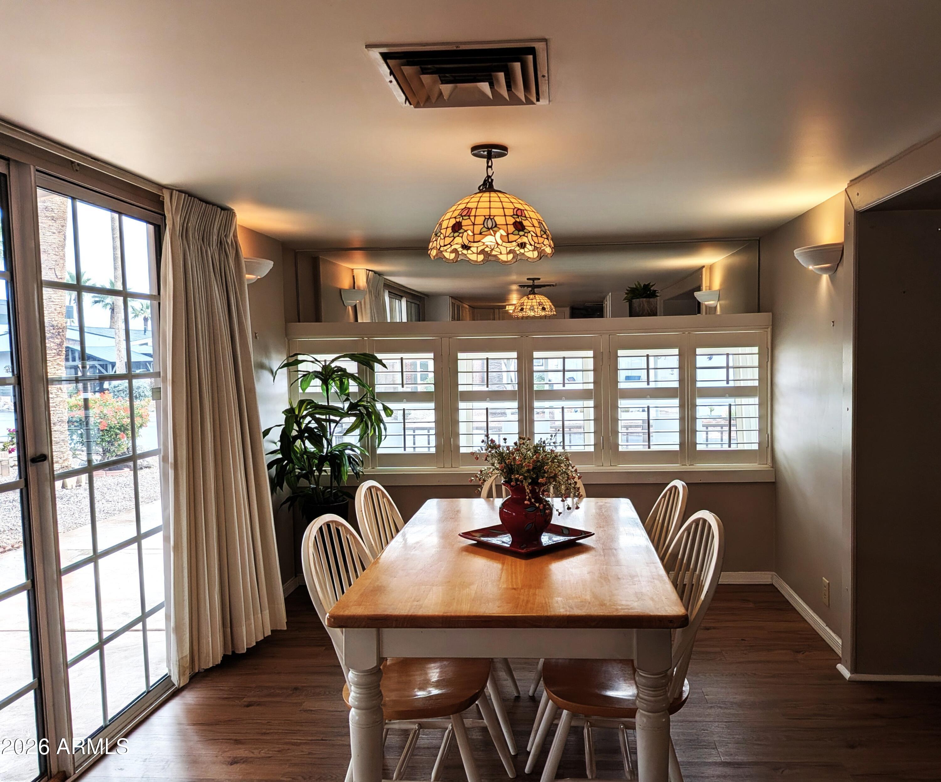 6700 East Thomas Road, Unit 25 Scottsdale, AZ 85251 - Photo 6 of 29 a view of a dining room with furniture wooden floor and chandelier