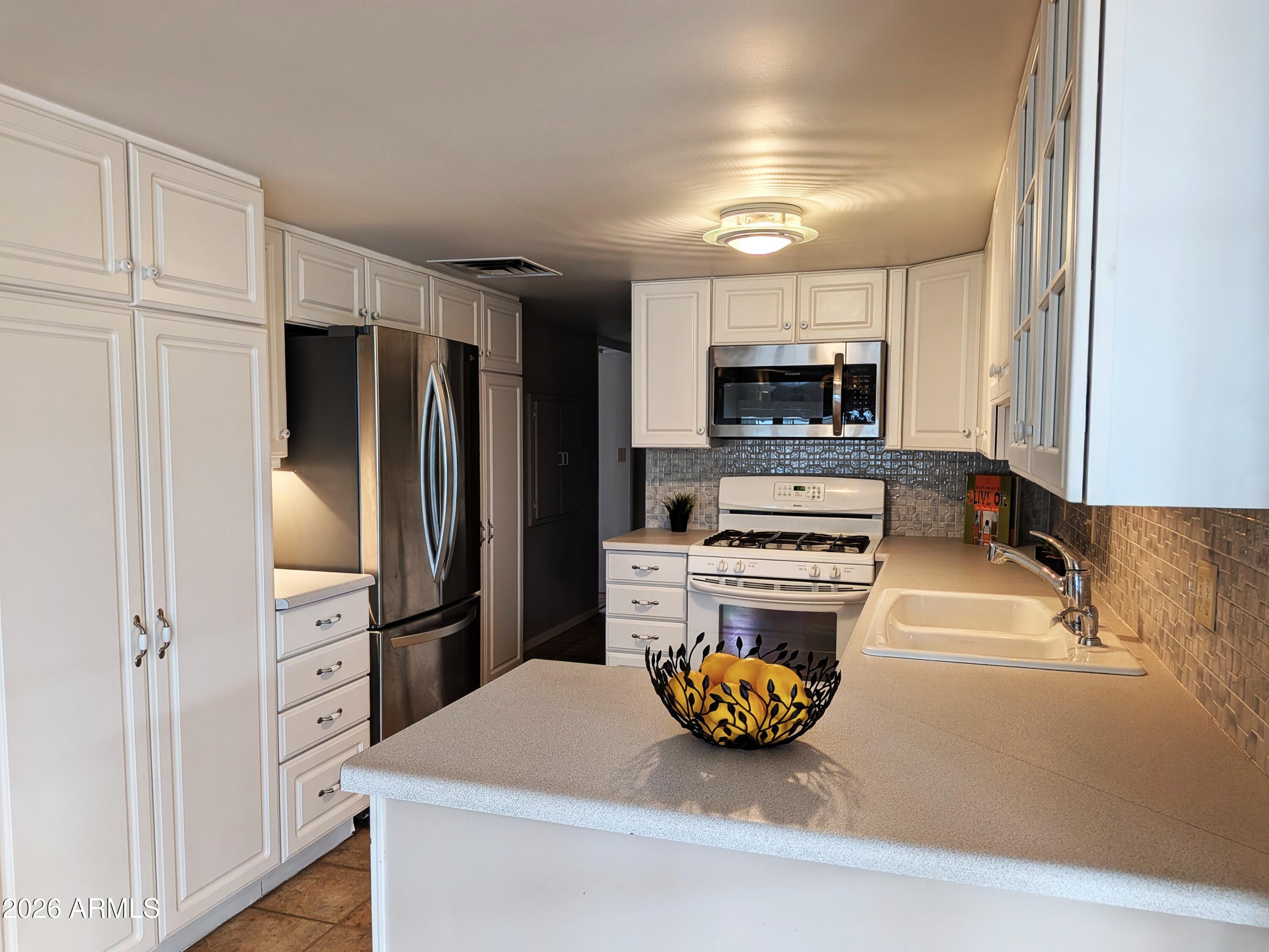 6700 East Thomas Road, Unit 25 Scottsdale, AZ 85251 - Photo 7 of 29 a kitchen with a refrigerator and a stove top oven