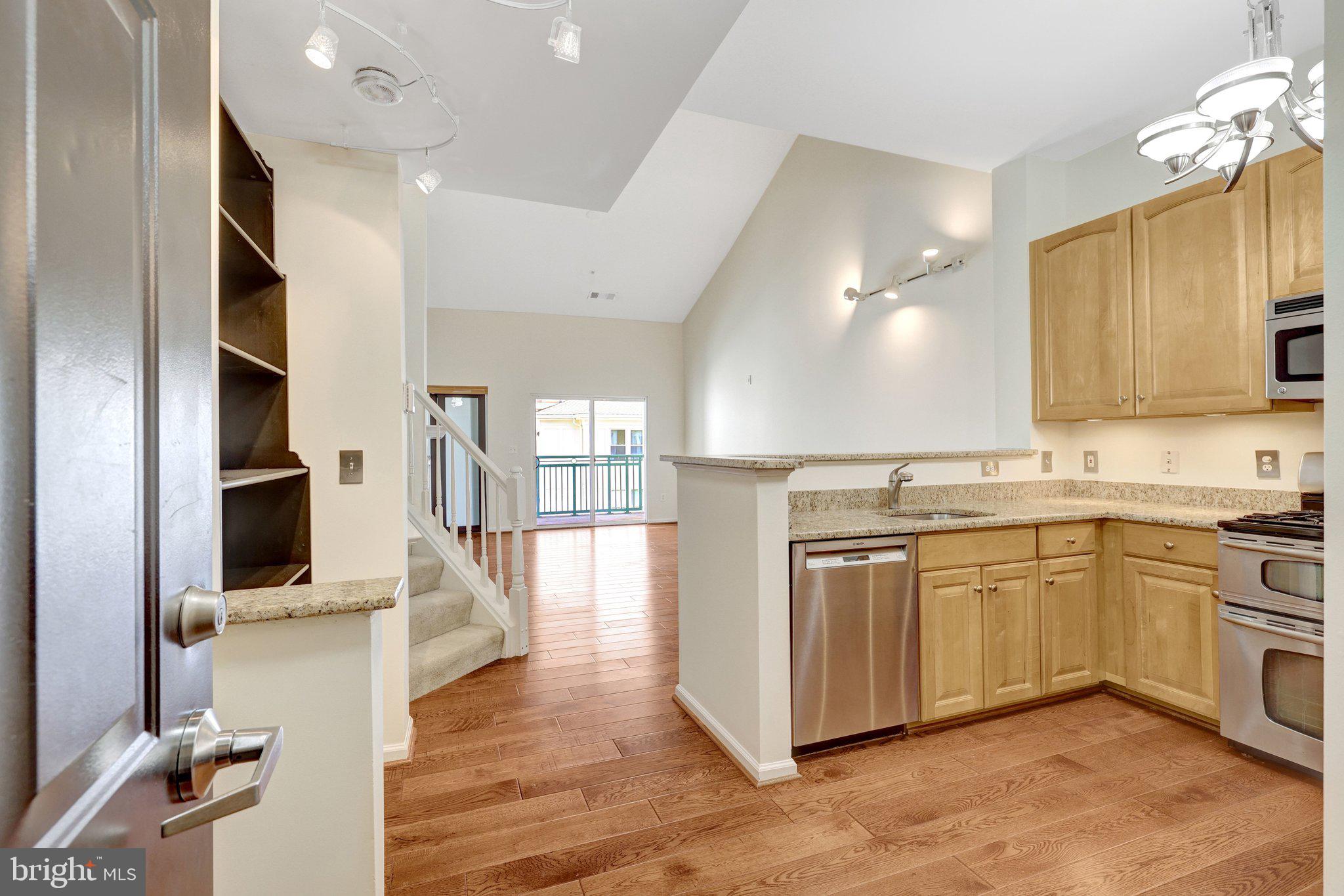 12001 Market Street, Unit 434 Reston, VA 20190 - Photo 11 of 43 a kitchen with stainless steel appliances granite countertop a stove and a sink