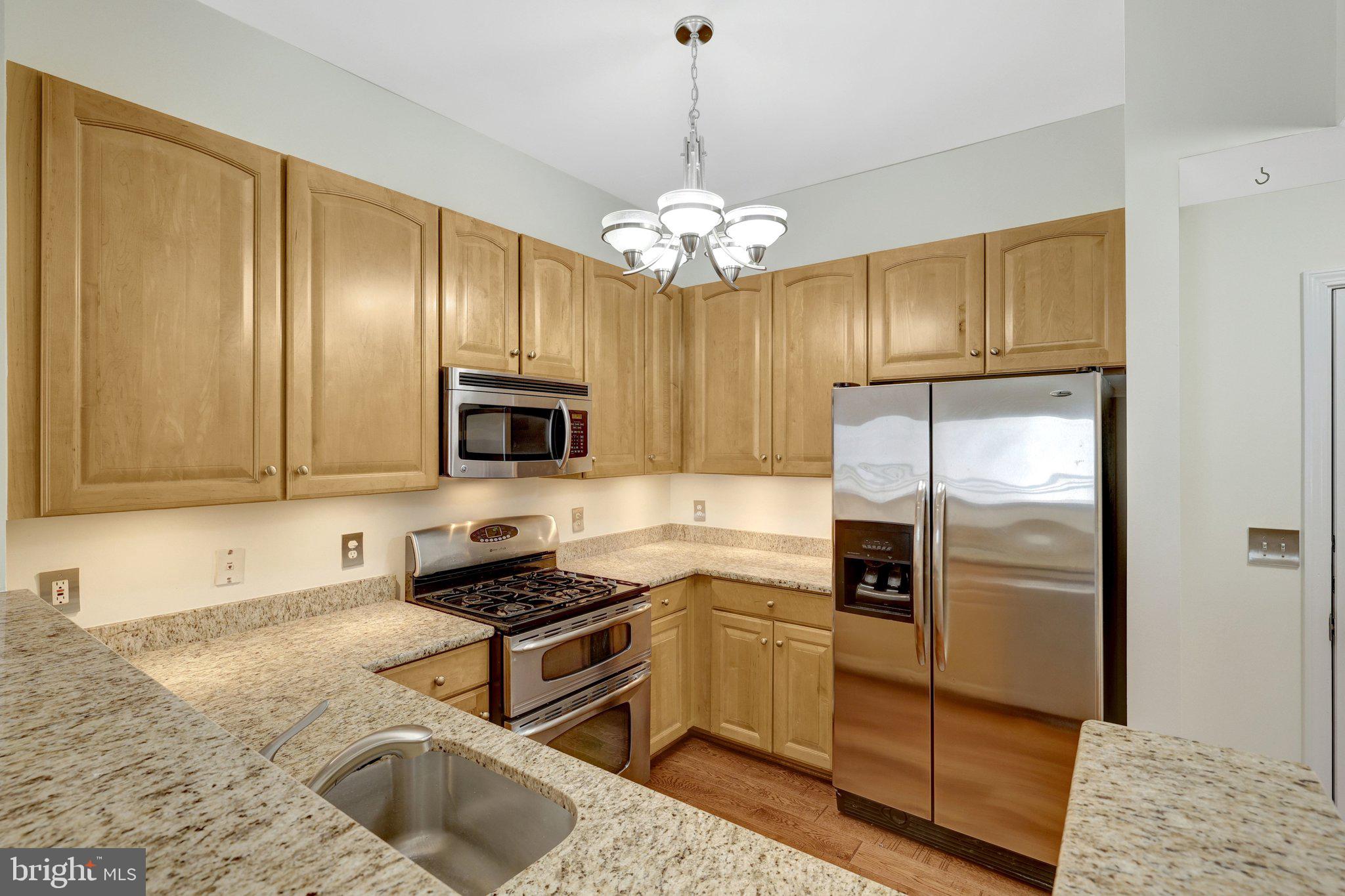 12001 Market Street, Unit 434 Reston, VA 20190 - Photo 12 of 43 a kitchen with stainless steel appliances granite countertop a refrigerator a stove a sink and dishwasher