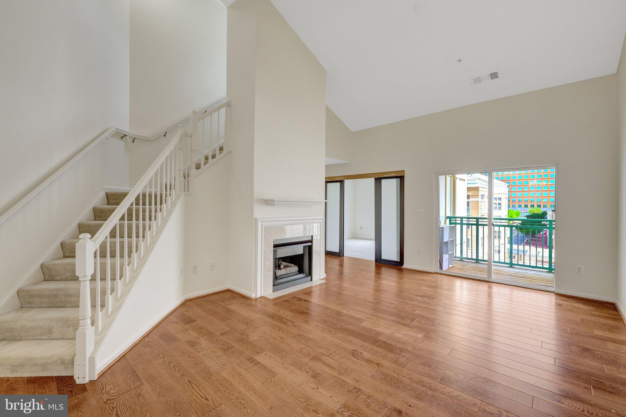 12001 Market Street, Unit 434 Reston, VA 20190 - Photo 13 of 43 a view of an empty room with wooden floor and a window